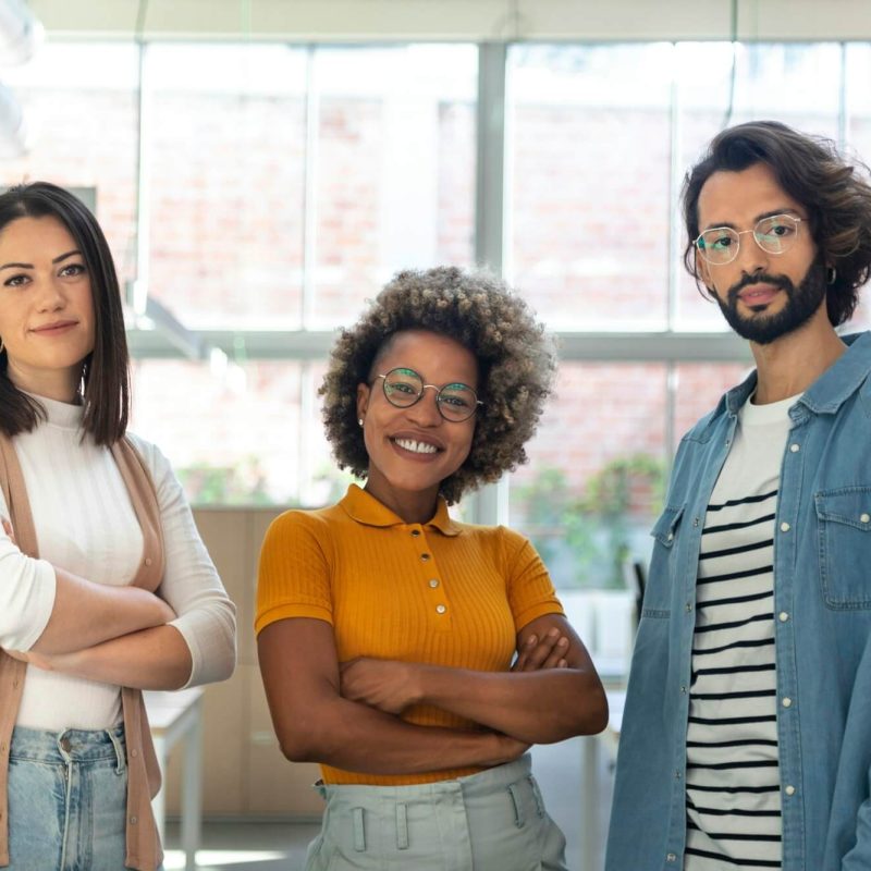 multiracial-coworkers-looking-at-camera-standing-in-bright-spacious-co-working-office-space-.jpg