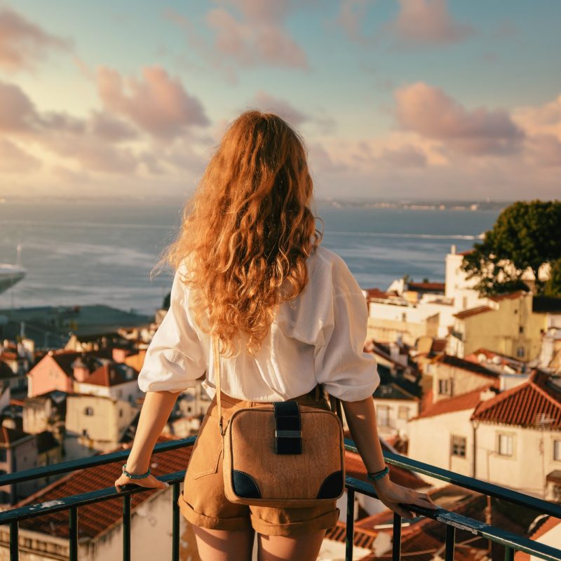 young-female-standing-platform-surrounded-by-fences-observing-lisbon-daytime-portugal